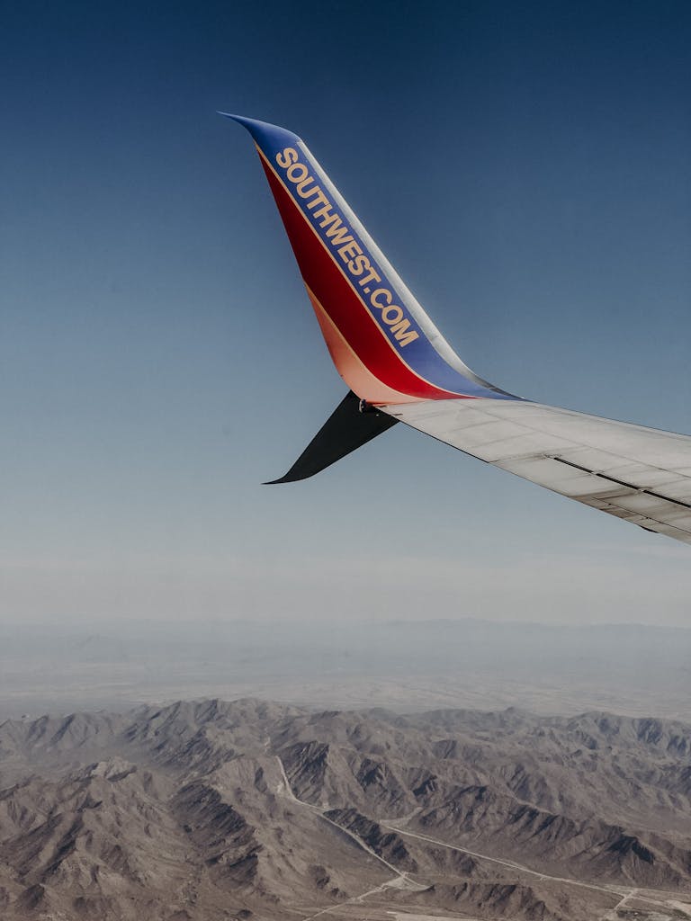 Wing of Airplane Flying over Rocky Mountains
